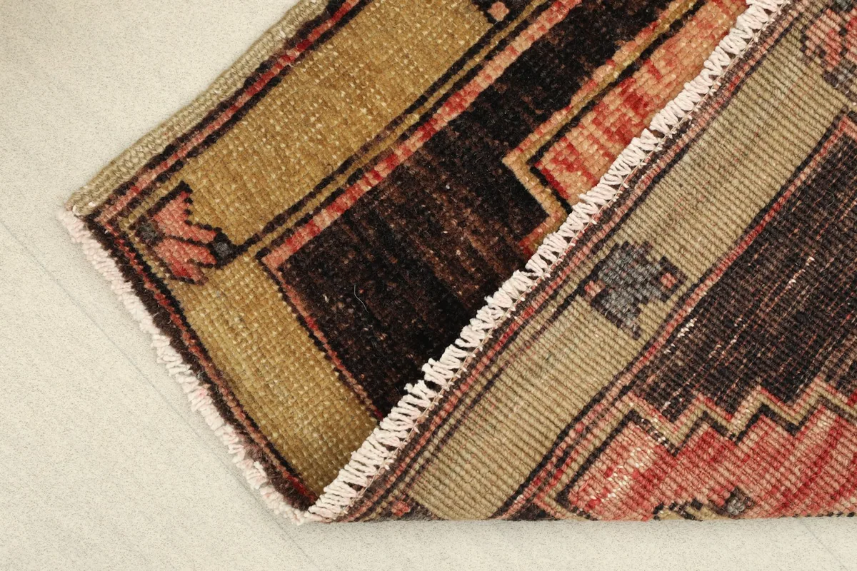 View of the rug folded to show the thickness and the short, natural fringes.