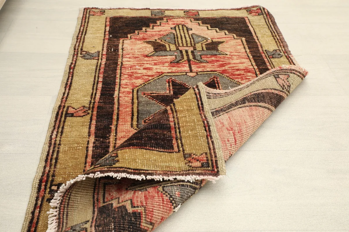 The rug partially folded, showcasing its flexibility and the wool pile on cotton foundation.