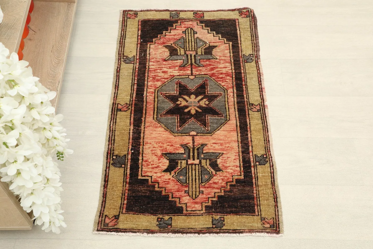 Overhead view of the hand-knotted rose and gray geometric rug, showing its full design.