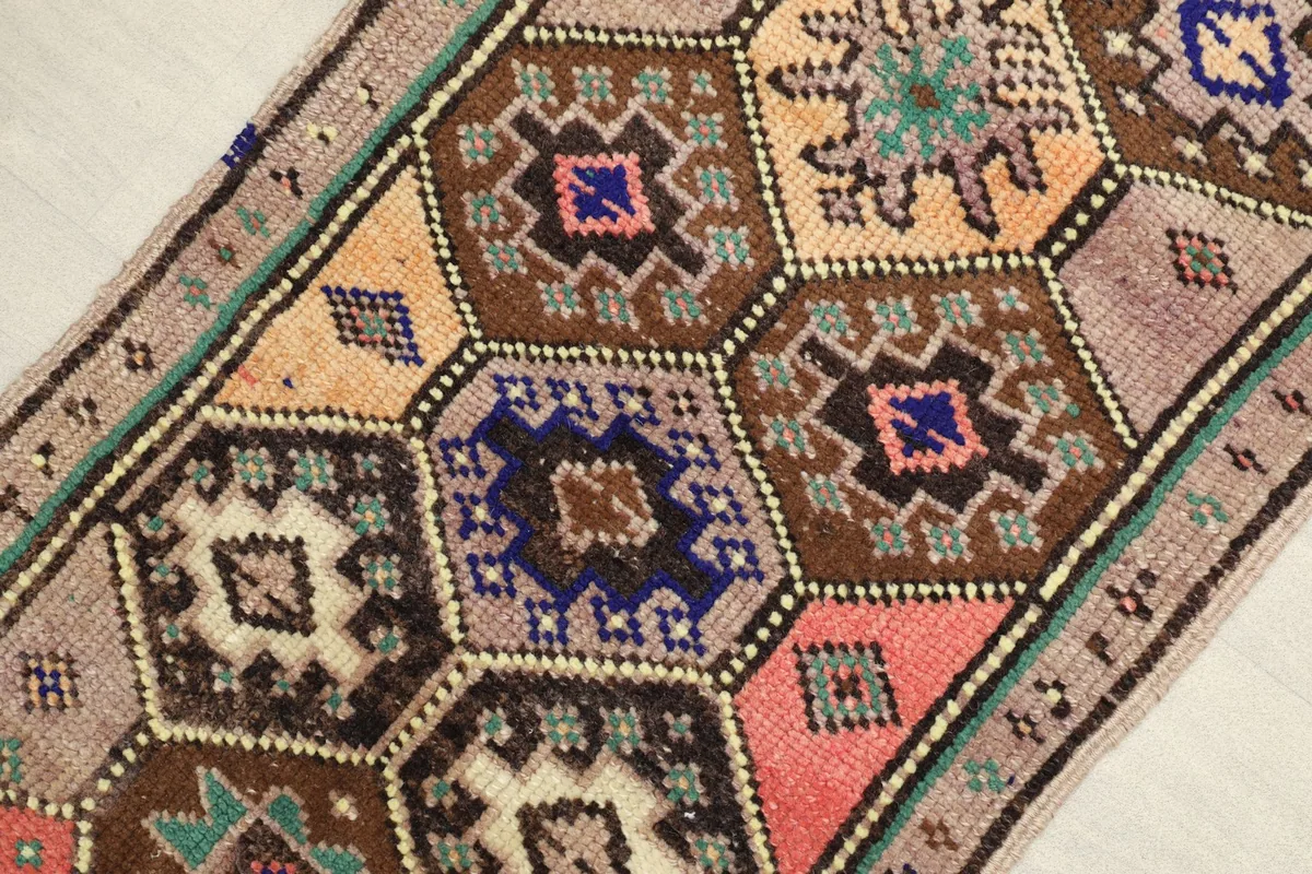 Close-up view of the intricate geometric hexagonal patterns in tan, brown, navy, pink, and orange colors.