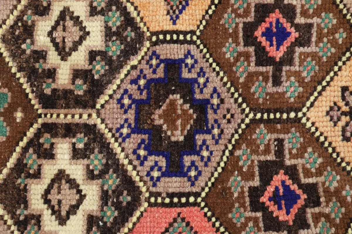 Detailed shot highlighting the varied colors and motifs within the individual hexagons of the vintage rug.