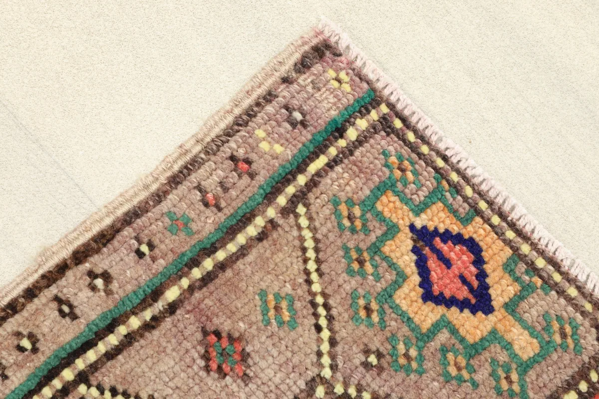 Corner detail showing the border design and the texture of the low wool pile.