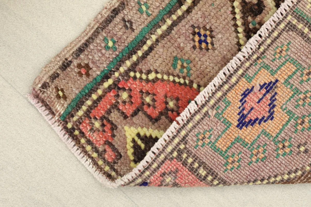 Folded corner of the rug, showing the reverse side's cotton foundation and hand-knotted structure.