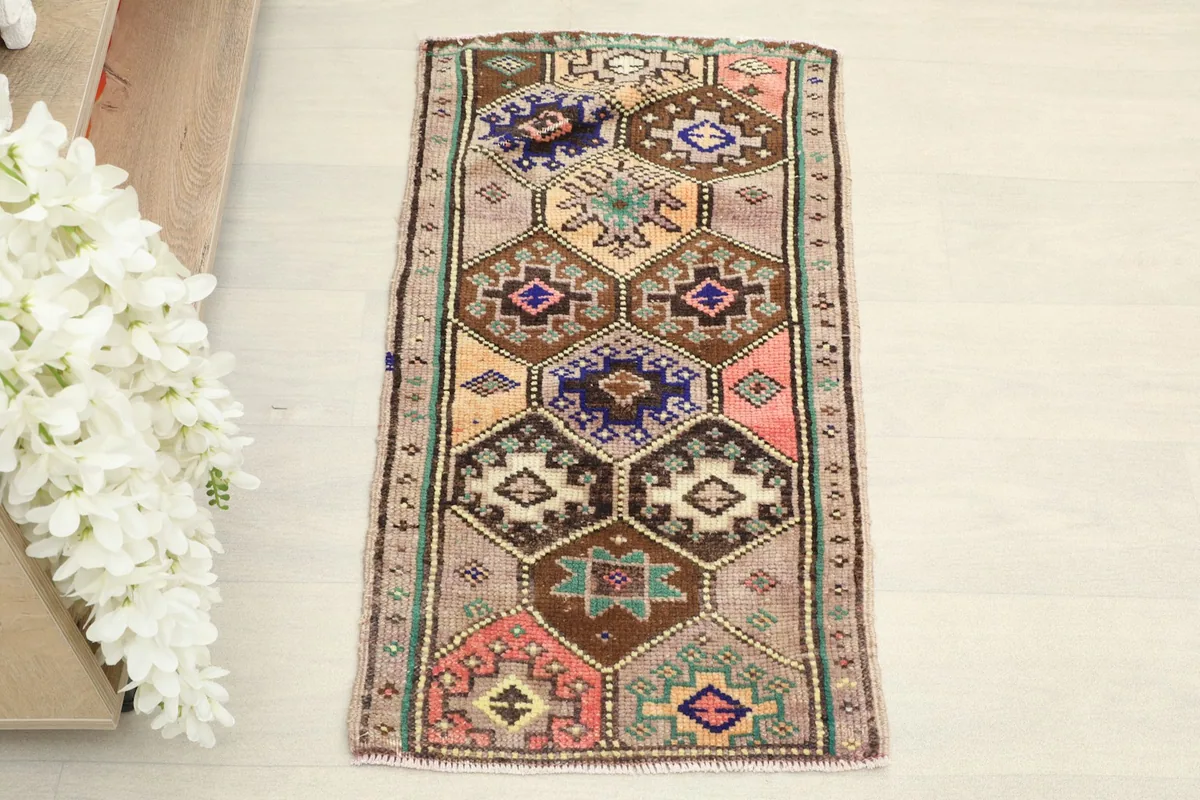 Overhead view showcasing the full pattern of the hand-knotted tan, brown, and navy rug.