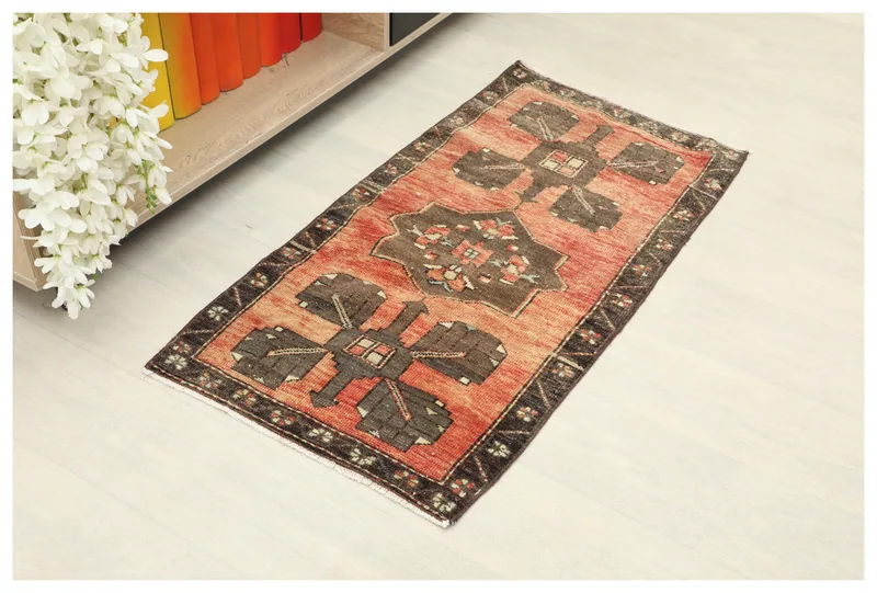 Full top view of the rust and brown geometric vintage Anatolian rug on a white background.