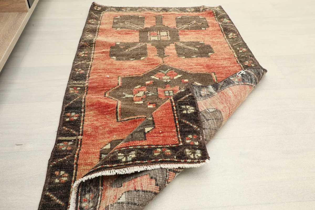 The rug partially folded, showing the texture of the wool pile and the hand-knotted construction.