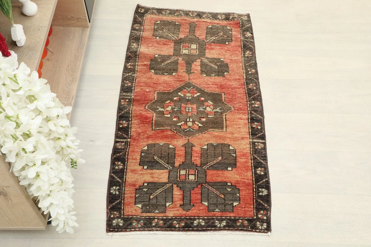 Overhead view of the vintage Anatolian rug, highlighting its rust and brown geometric patterns.