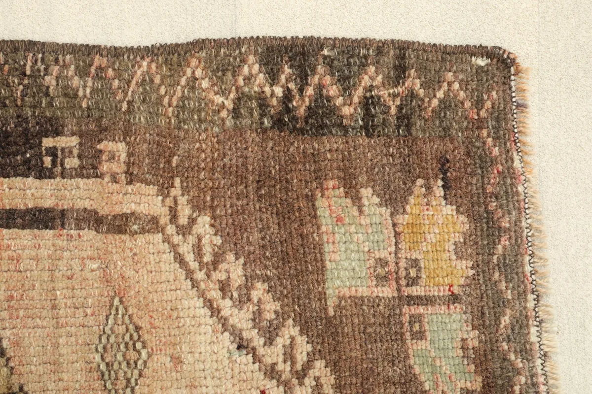 Detail view of the rug's border, displaying the zigzag pattern and fringe edge.