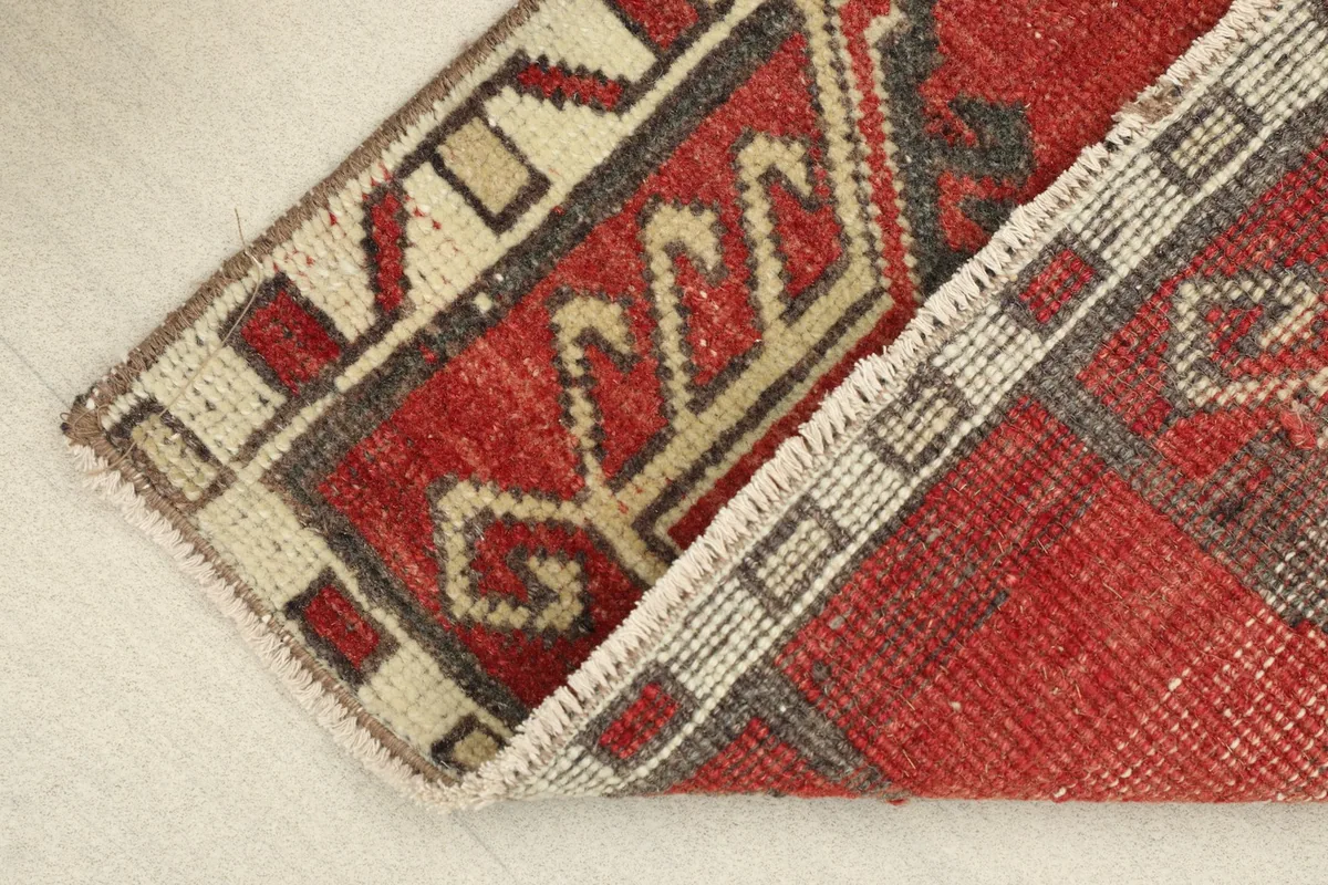 View of the rug's low pile and fringe along one edge, showing its wool texture