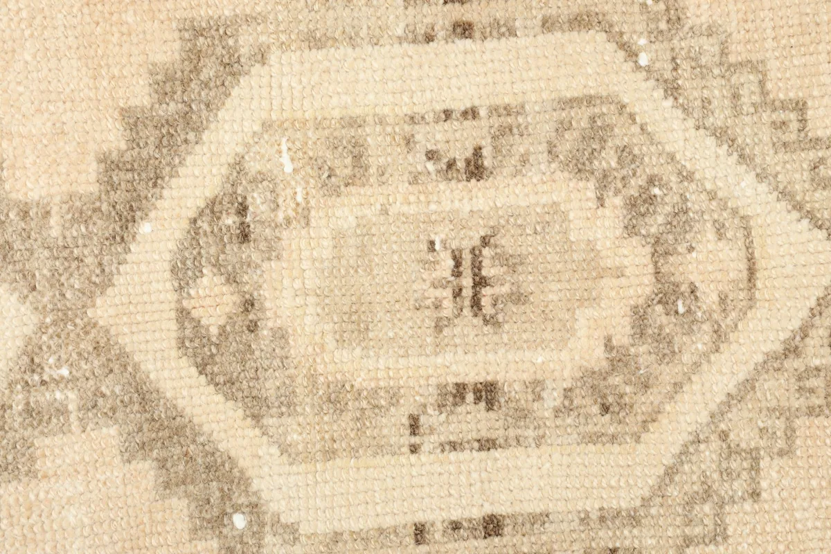 Detailed close-up of the hand-knotted texture and intricate geometric patterns of the rug's center.