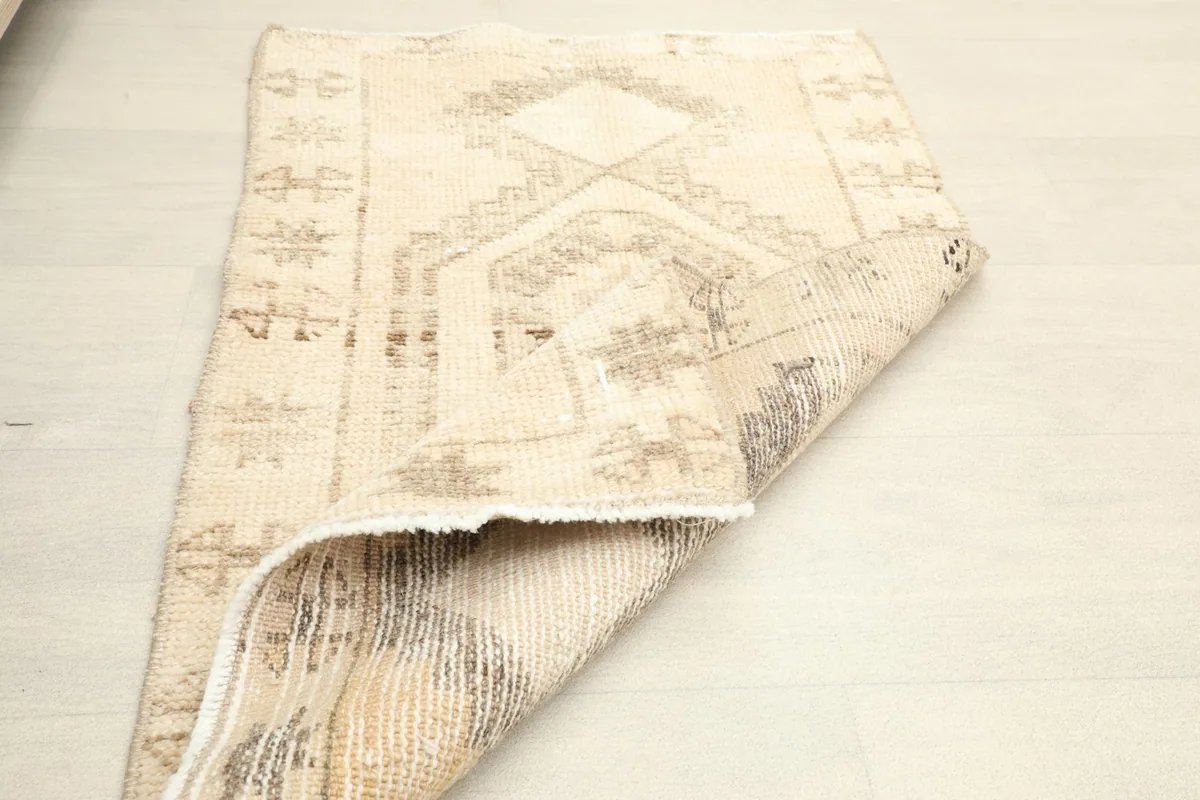 The rug folded to reveal the reverse side, showing the tight hand-knotted construction and foundation.