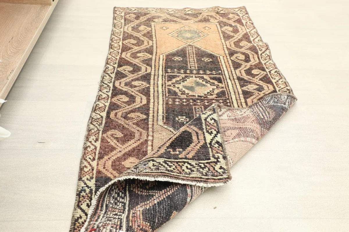 The rug placed in a room setting, partially folded, to illustrate its size and style.