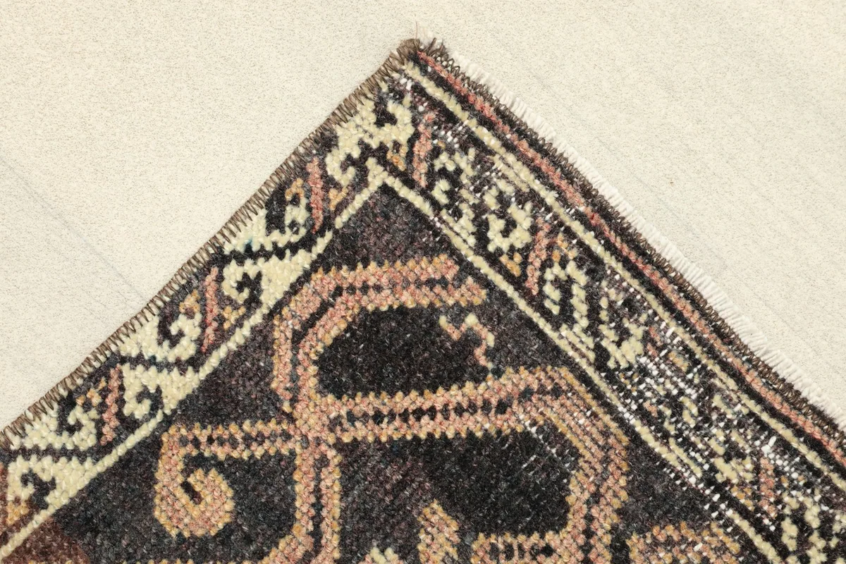Corner detail of the rug, showing the hand-knotted wool pile and border patterns.