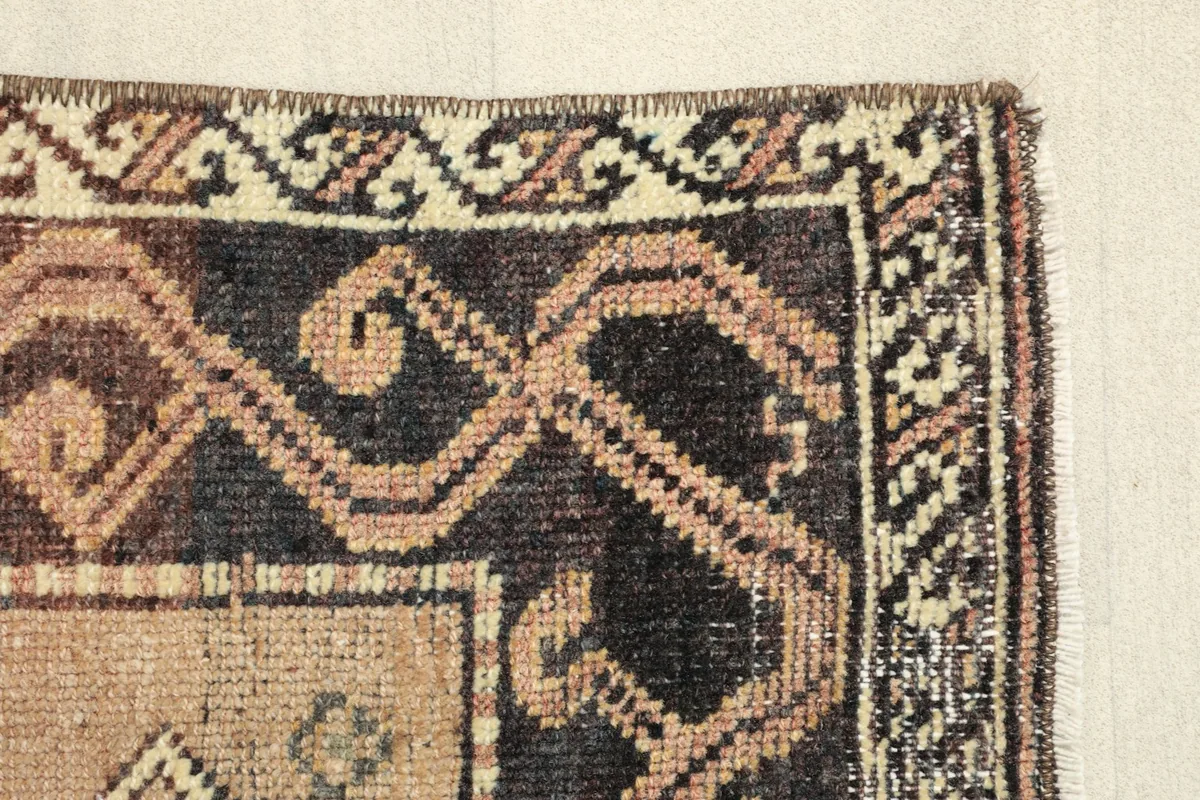 Close-up of the rug's edge and border, revealing the weaving texture and color variations.