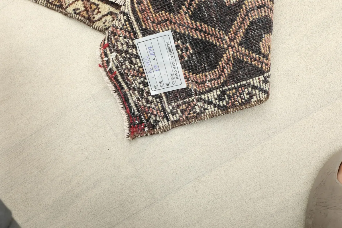 Underside of the rug with a label, showing the cotton foundation and knotting.