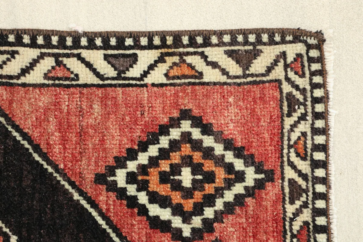 Close-up of the rug's edge, highlighting the hand-knotted texture and border patterns.
