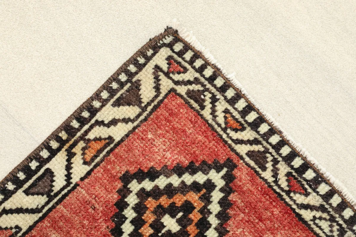 Close-up of a corner, showing the detailed beige and black border design.