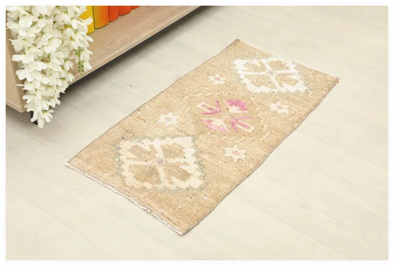 Full top view of the 1x3 beige and pink vintage Anatolian rug on a white background