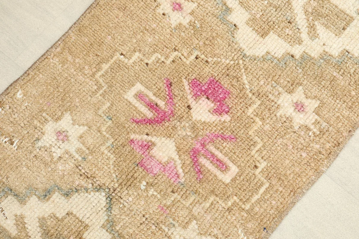 Close-up view of the central pink and ivory geometric motif and surrounding details