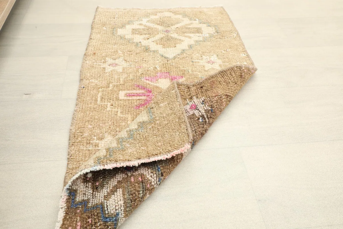 The rug partially folded, showing the flexibility and density of the vintage wool material