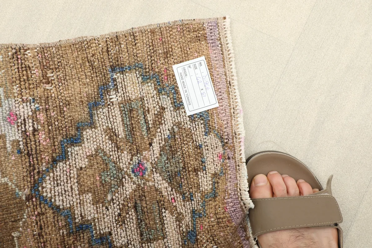 A foot next to the rug, providing a sense of scale for the doormat size