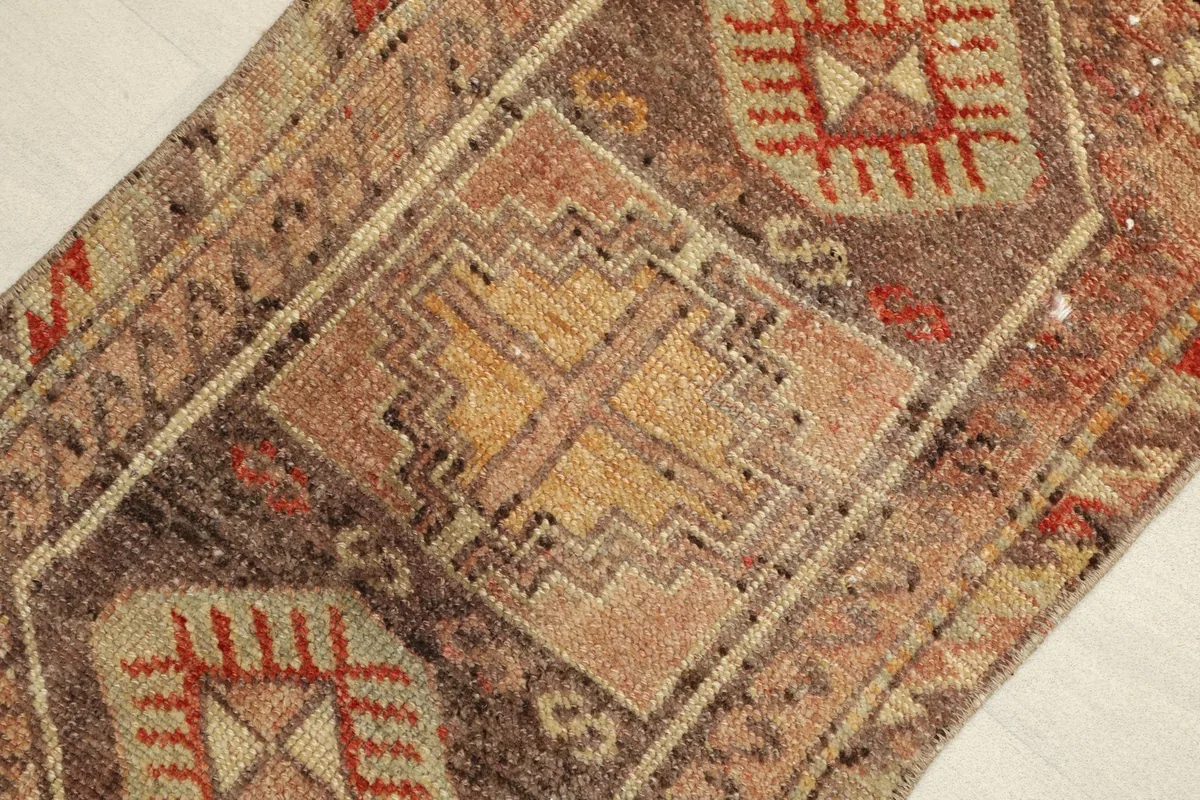 Angled view of the rug's center, showing the intricate geometric patterns and color variations.