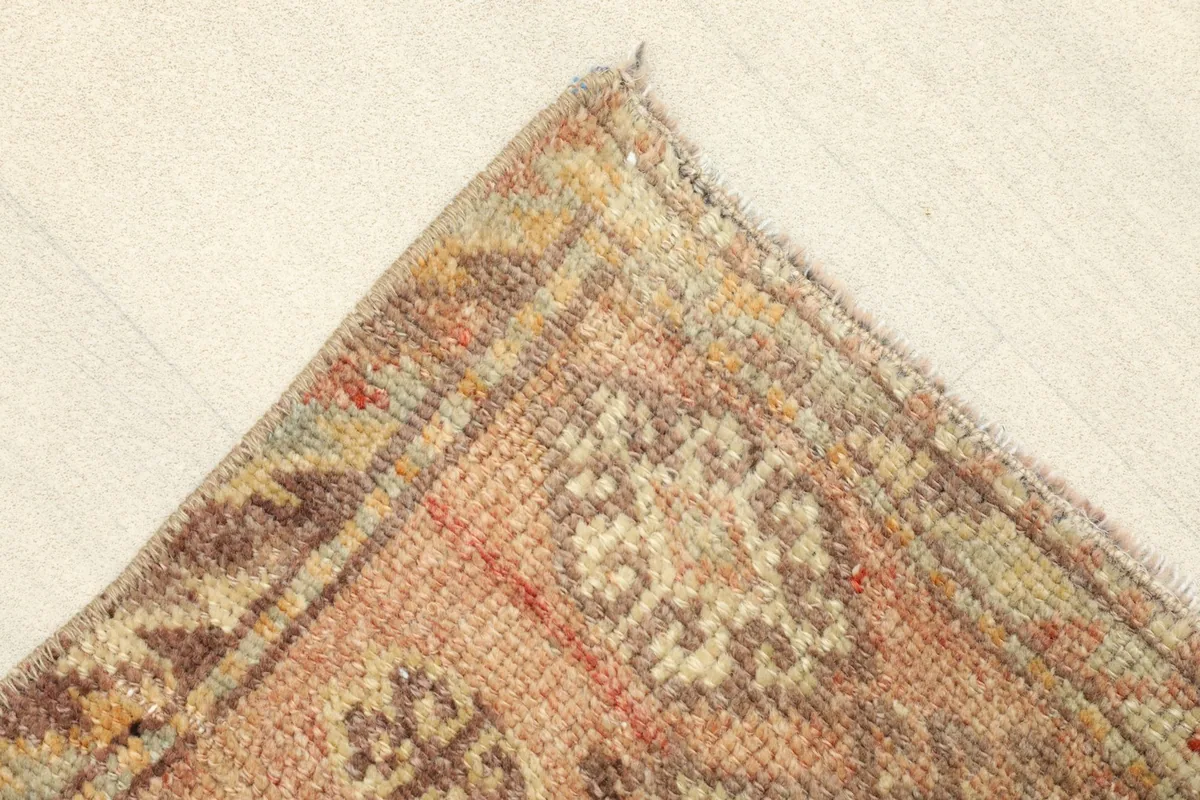 Corner detail of the rug, showing the subtle border design and the texture of the vintage wool.