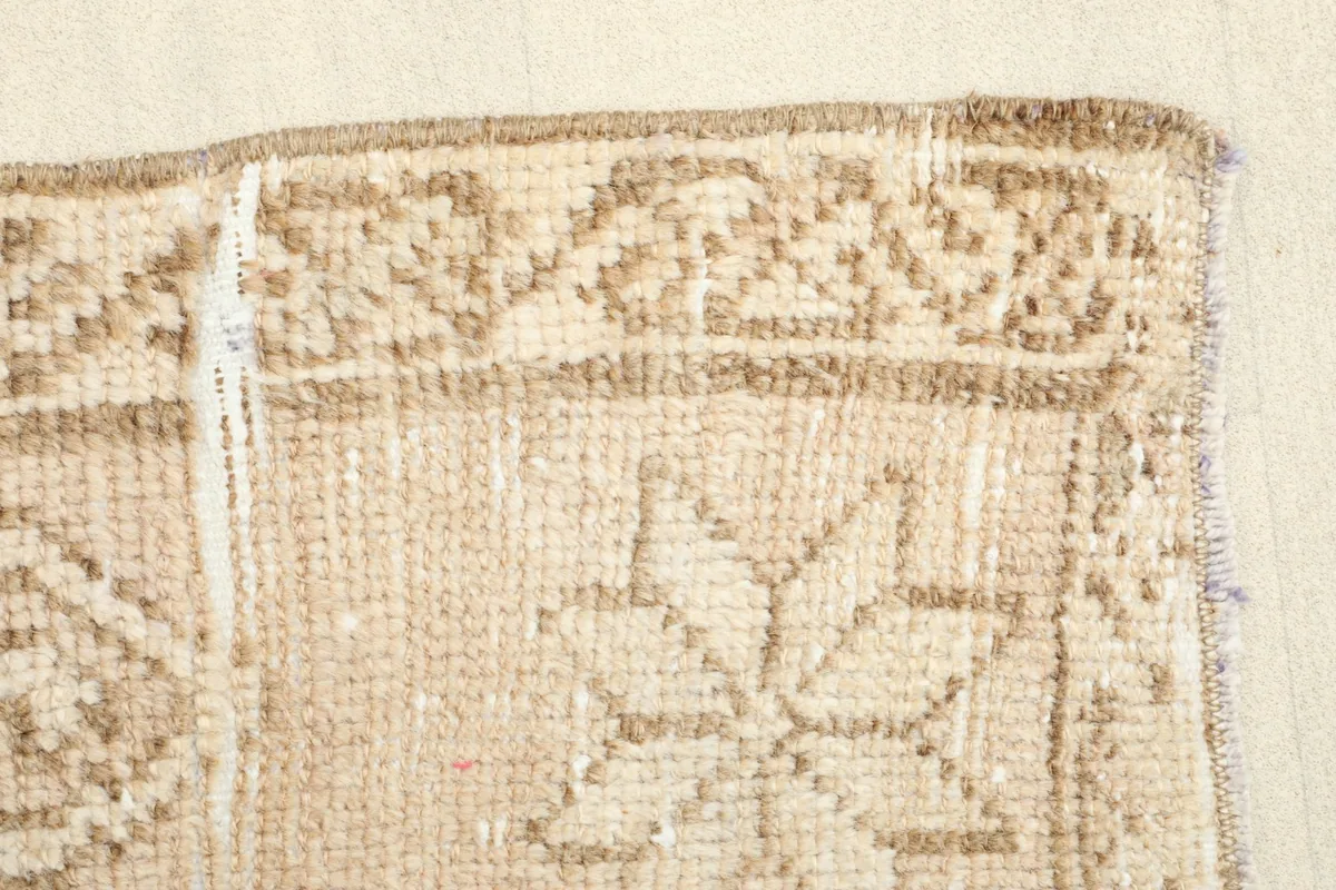 Edge view of the rug, detailing the woven border and the condition of the edges.