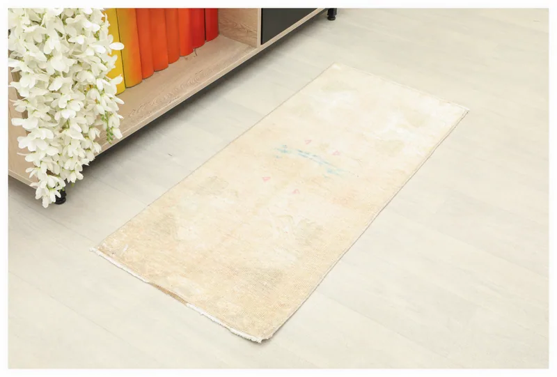 Full top view of the 1'7" x 3'6" beige vintage Anatolian doormat rug on a light floor.