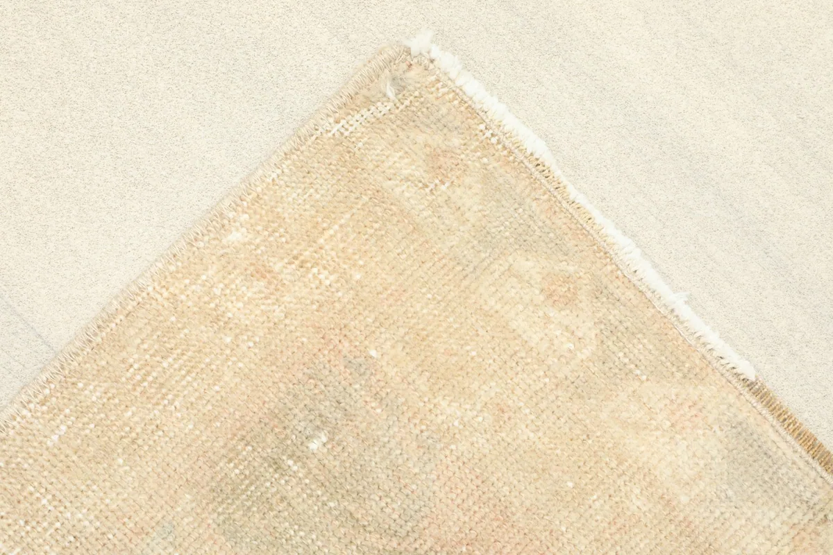 Corner view of the rug's back, revealing the cotton foundation and hand-knotted construction.