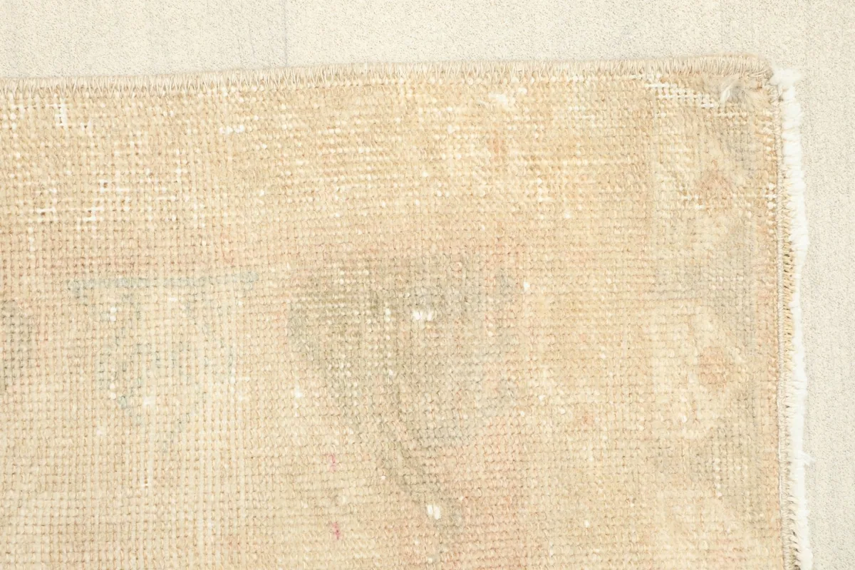 View of the back of the rug, showing the consistent weave of the cotton foundation.