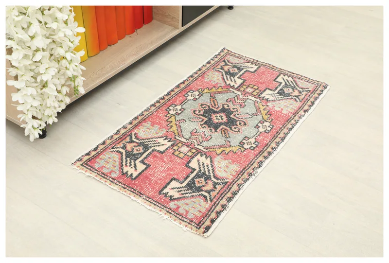 Full top view of the 1'8" x 3'1" vintage Anatolian rug with red field and geometric motifs.