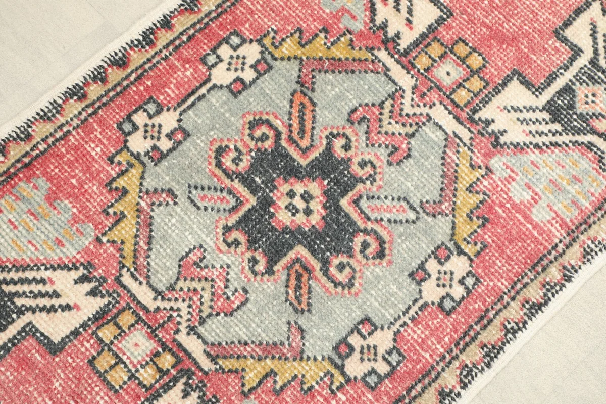 Close-up of the central gray medallion and surrounding red and black geometric patterns.