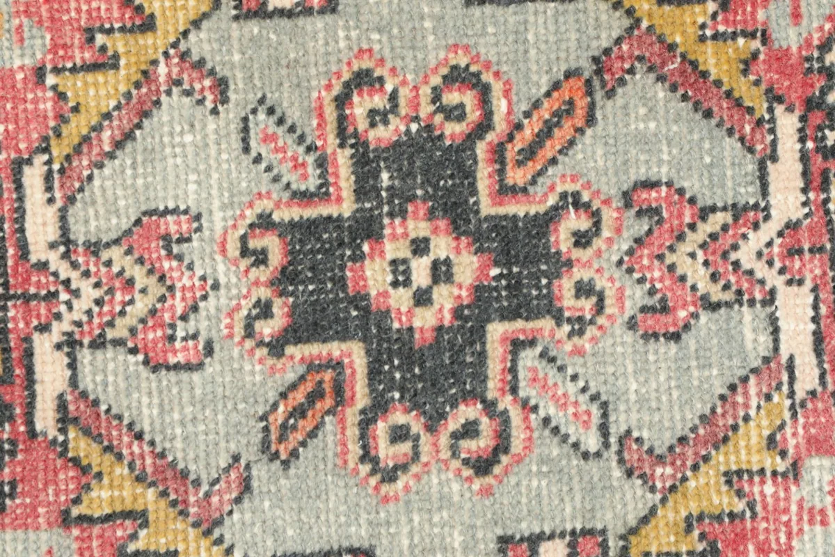 Detailed view of the intricate geometric pattern within the central medallion, showing wool texture.