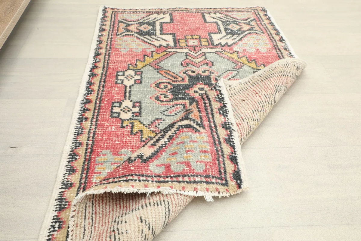 The rug folded to show its flexibility and the reverse side with visible knotting.