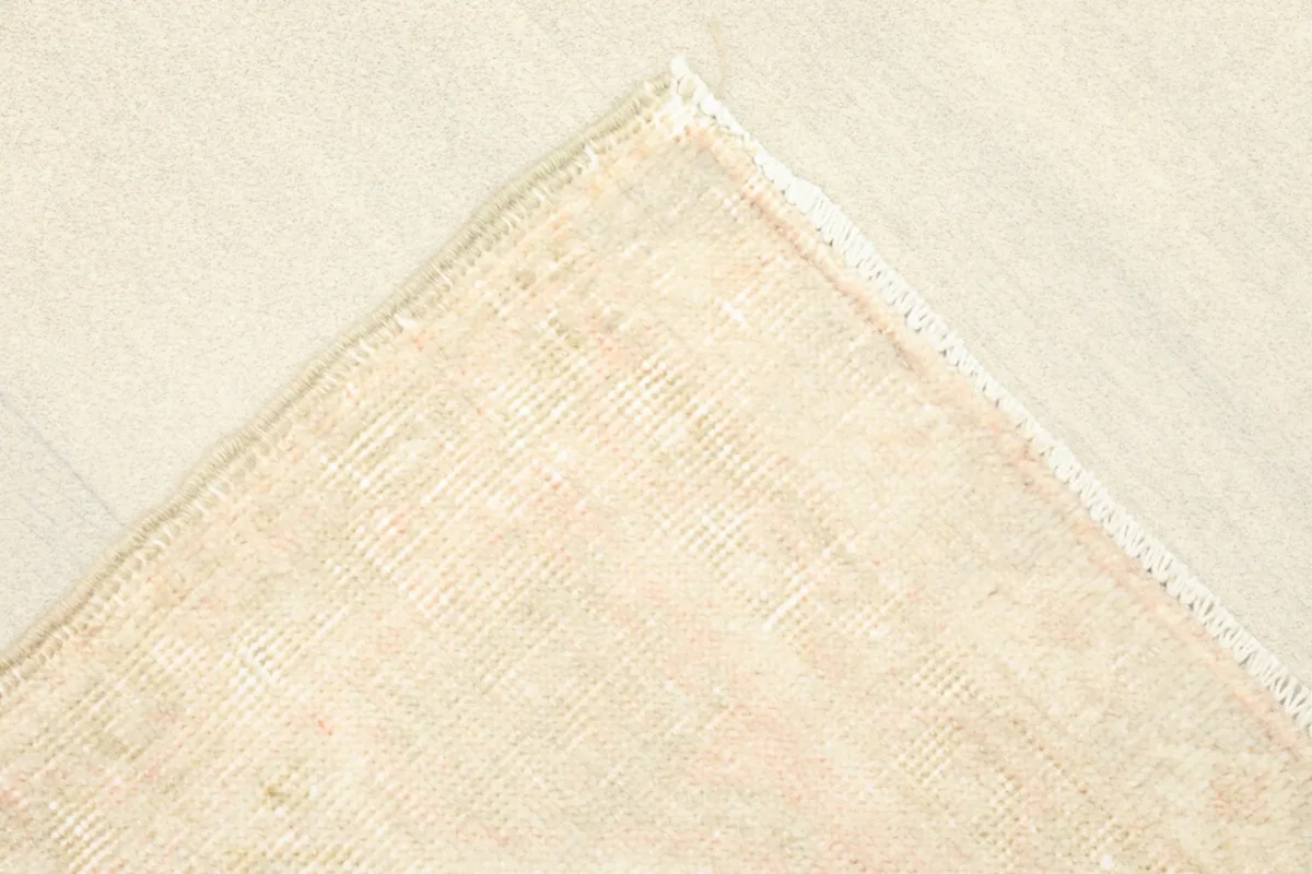 Corner view of the rug's back, revealing the hand-knotted cotton foundation