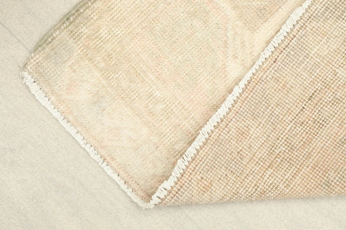 Partial fold of the rug, displaying the front pile and the reverse side of the foundation