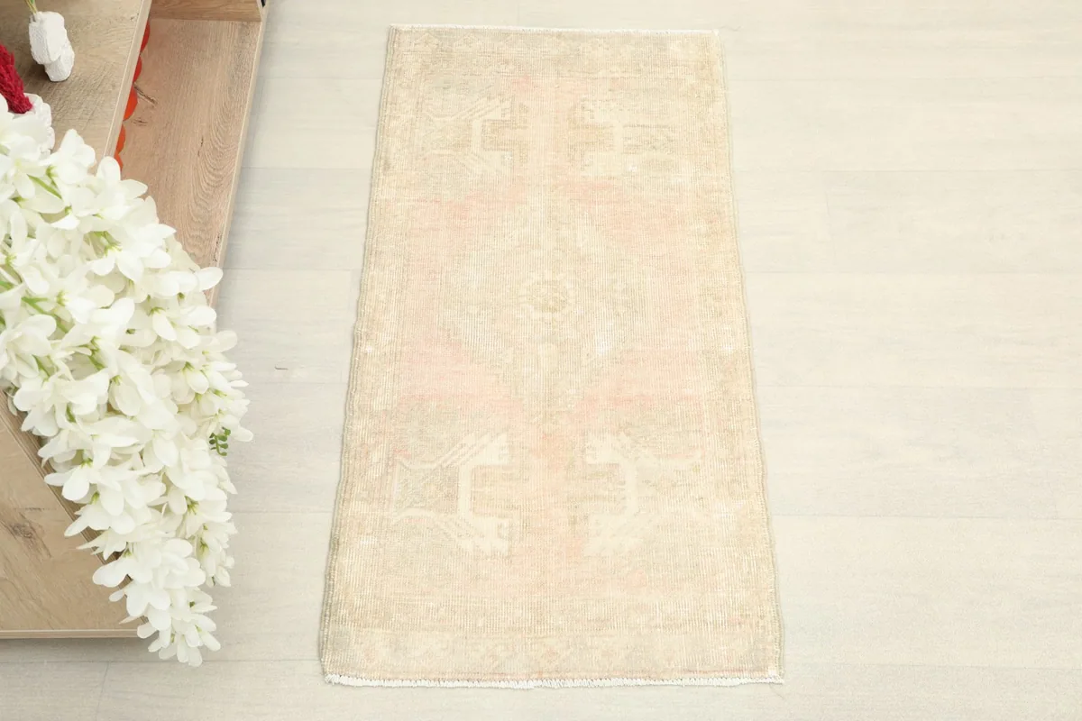 Overhead view of the vintage beige and rose rug, showcasing its full length and width