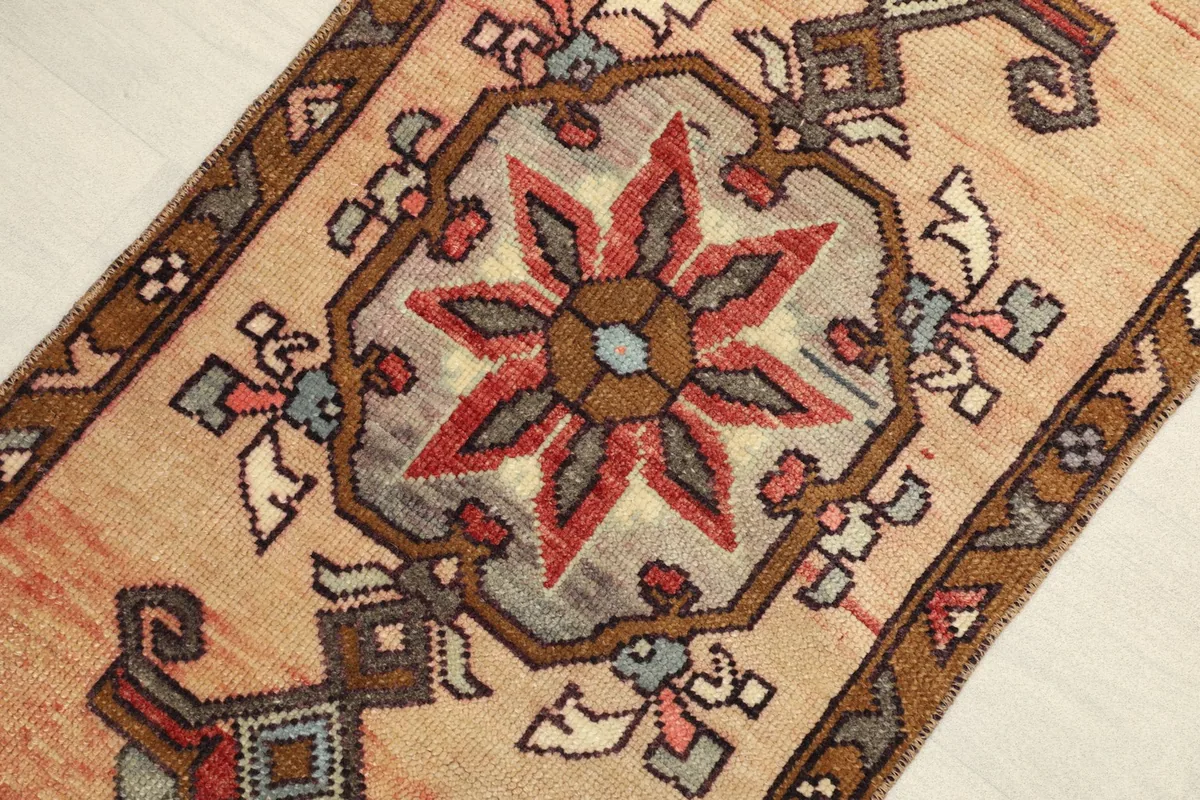 Close-up detail of the central tribal medallion with red, blue, and brown patterns.