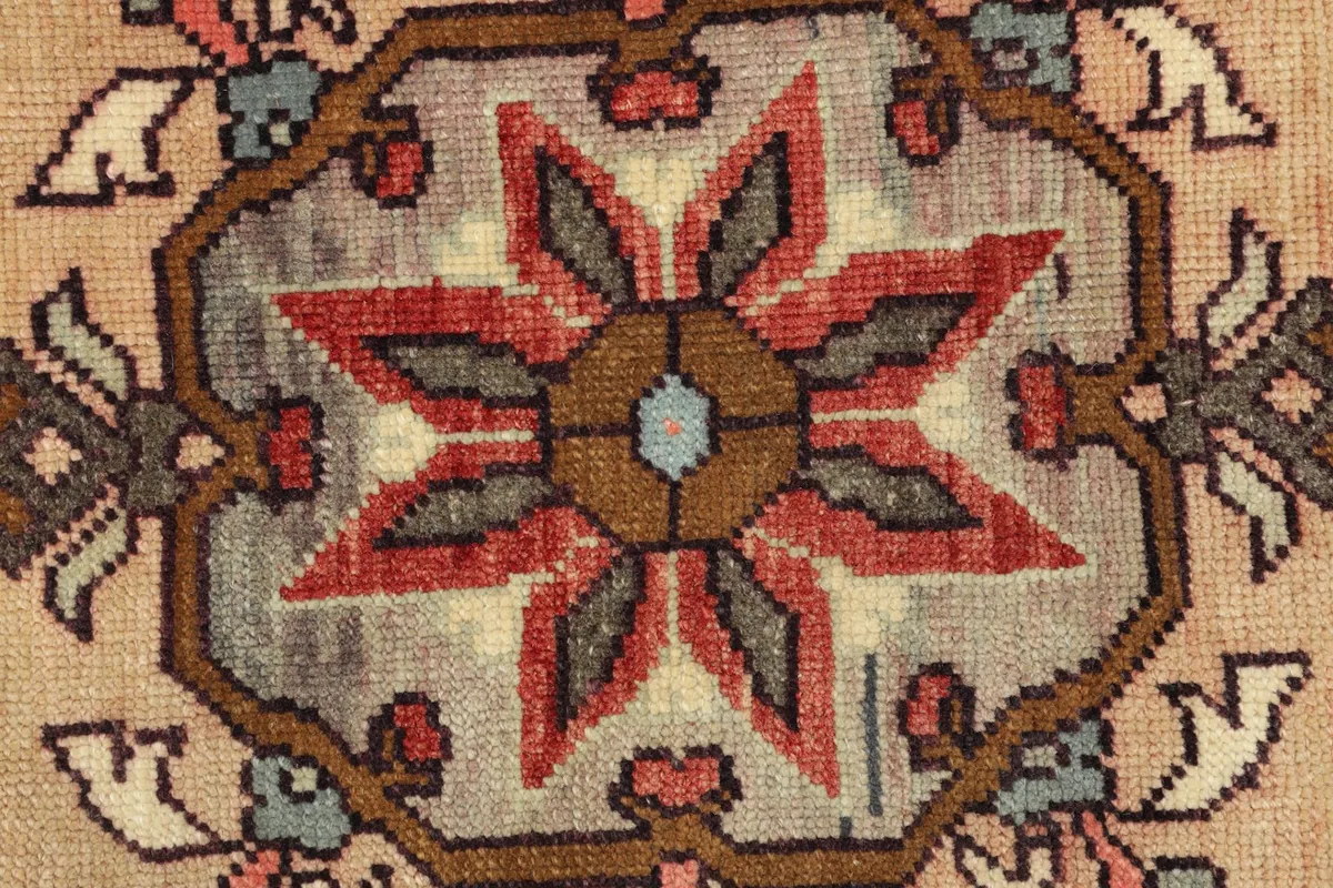 Detailed view of the intricate hand-knotted knots and color variations within the medallion.