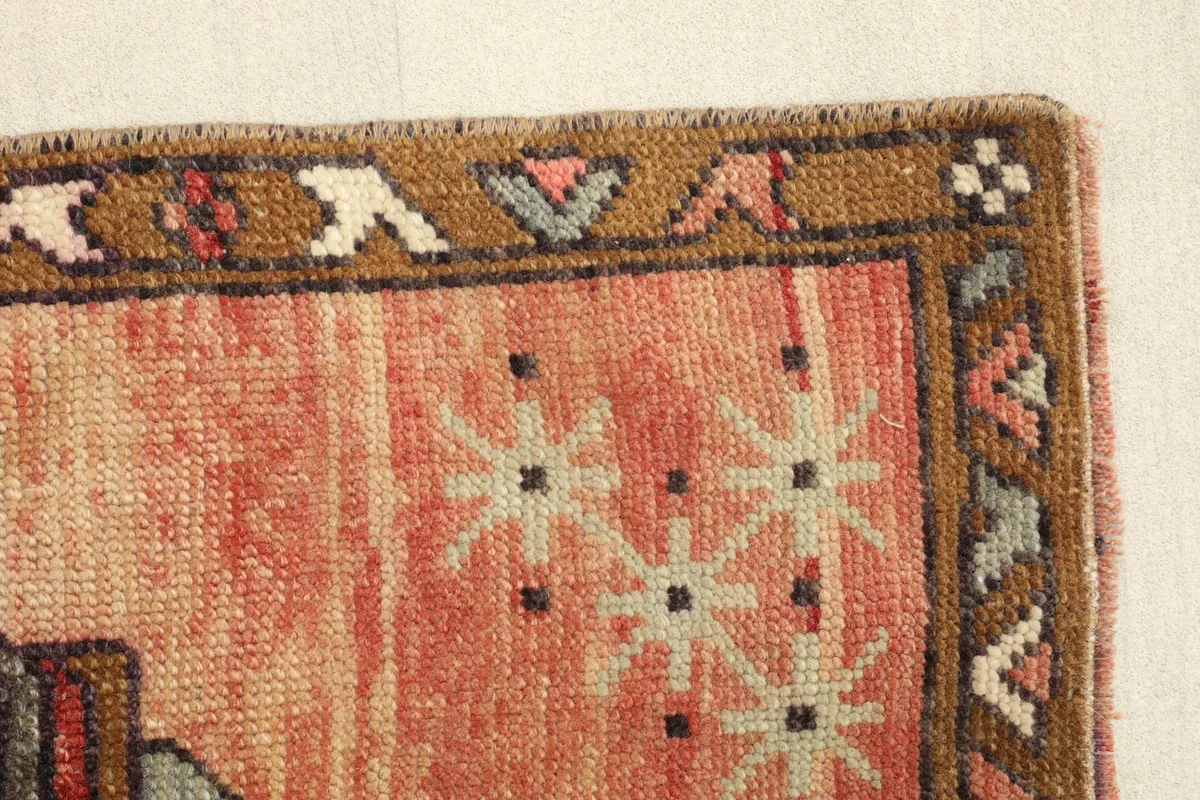 Edge detail, highlighting the geometric border design and the texture of the wool pile.