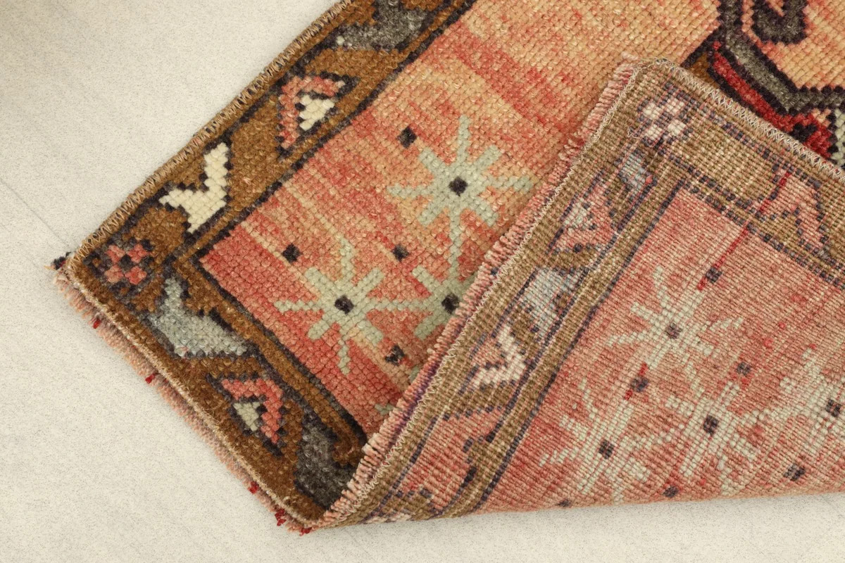 View of the rug folded to show the thickness and the back of the hand-knotted construction.
