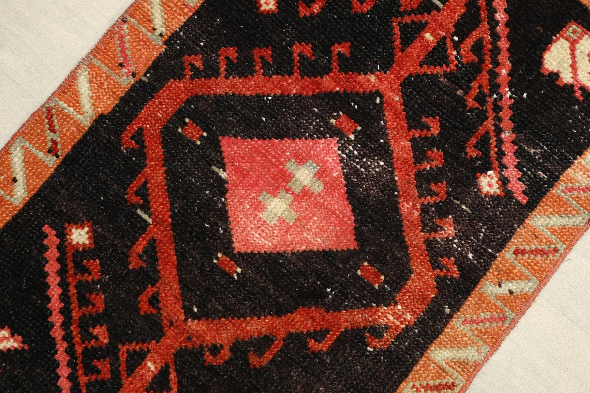 Close-up view of the central red and orange geometric medallion on the black field.