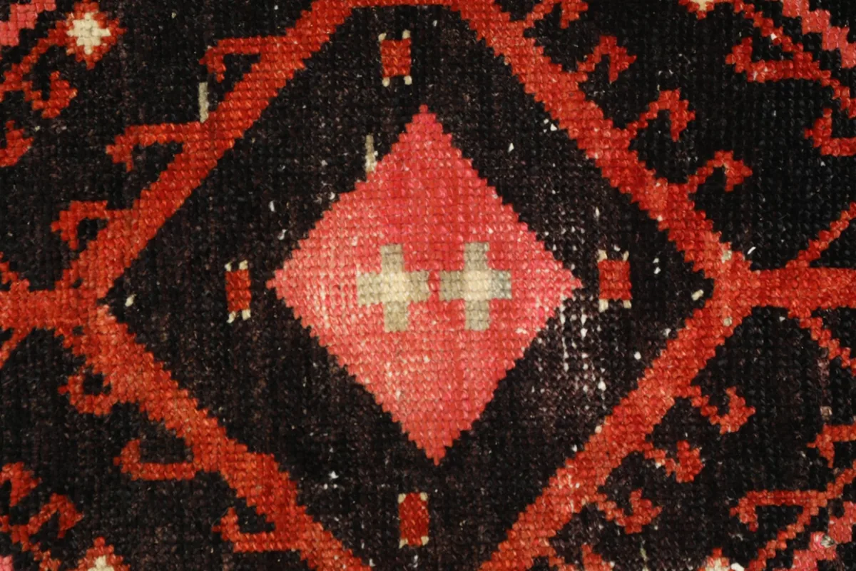 Detailed shot of the central motif, highlighting the subtle color variations and texture of the wool pile.
