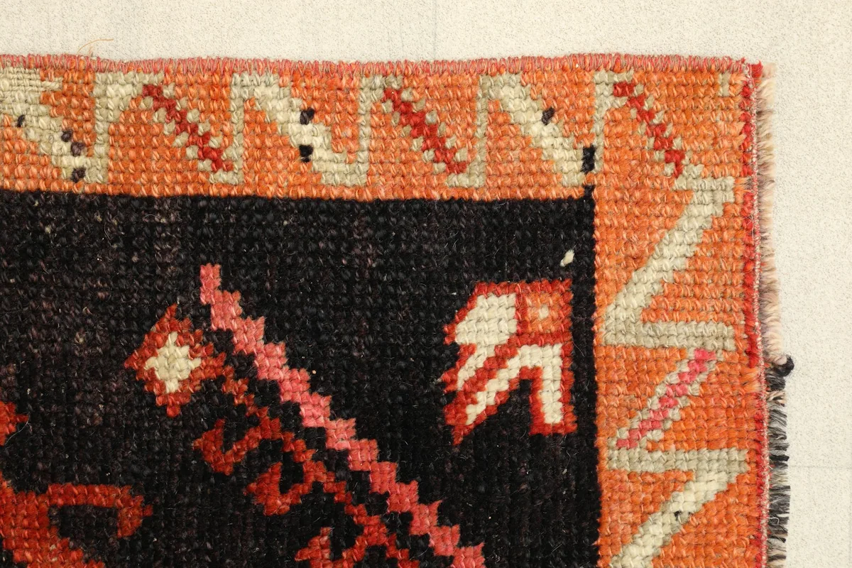 Close-up of the rug's edge, displaying the intricate border design and hand-knotted construction.