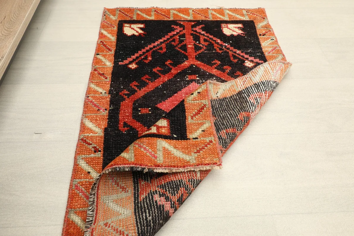 Partial view of the rug's underside, revealing the hand-knotted cotton foundation.
