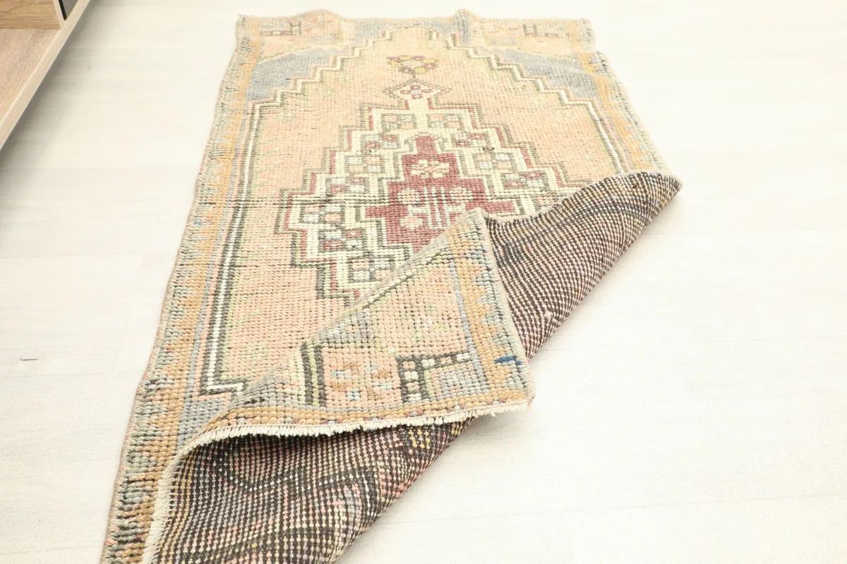 The rug partially folded, displaying both the front and the reverse side with its tightly woven foundation.