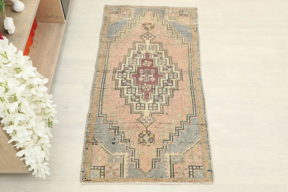 Overhead view of the hand-knotted vintage rug, showing its rose field and gray geometric border.