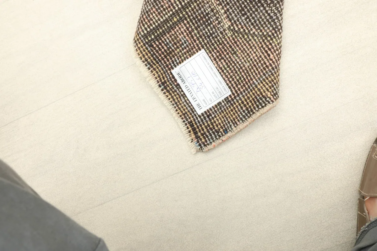 A partial view of the rug's reverse side, showing the hand-knotted structure and a product label.