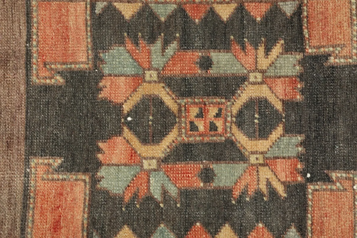 Detailed view of the intricate geometric patterns and colors in the rug's center